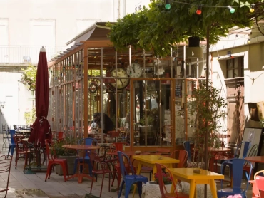 Sunny cafe terrace with colorful bistro chairs in Saint-Rémy-de-Provence.