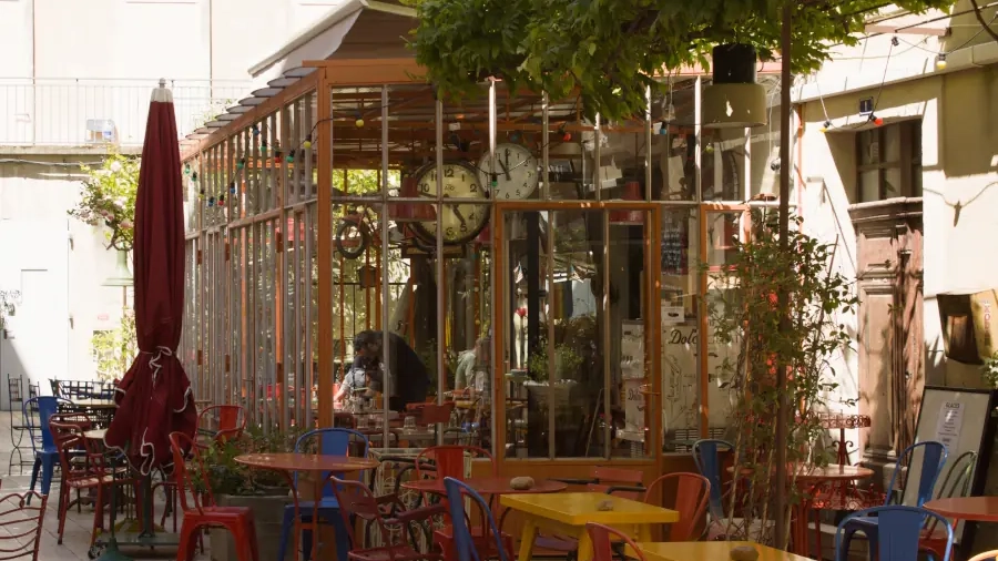 Sunny cafe terrace with colorful bistro chairs in Saint-Rémy-de-Provence.