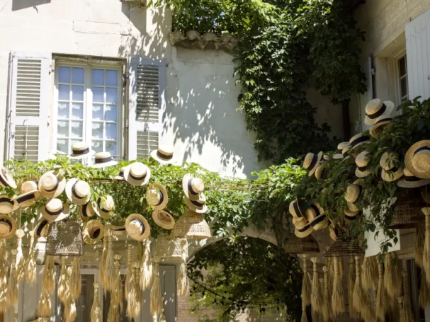 Chic boutique window display with artisanal straw hats in Saint-Rémy-de-Provence.