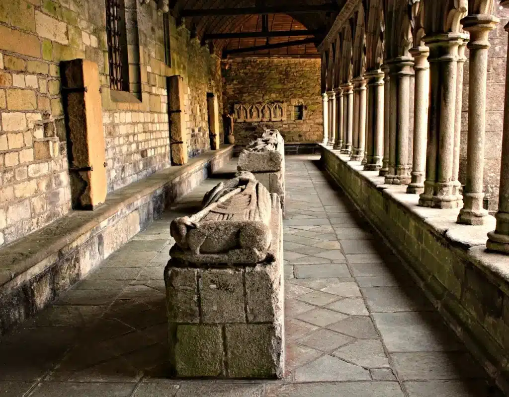 The Gothic cloister of Tréguier Cathedral in Brittany, showing the perspective of the stone gallery and medieval recumbent effigies