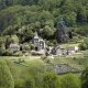 Panoramic view of Saint-Paul-de-Salers, Cantal, France, featuring the iconic volcanic rock and the Virgin Mary statue.
